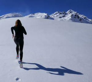 women running across snow - ski trip preparation
